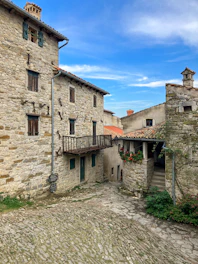 A charming village square in Burgos with traditional houses and cobblestone streets under a bright sky.