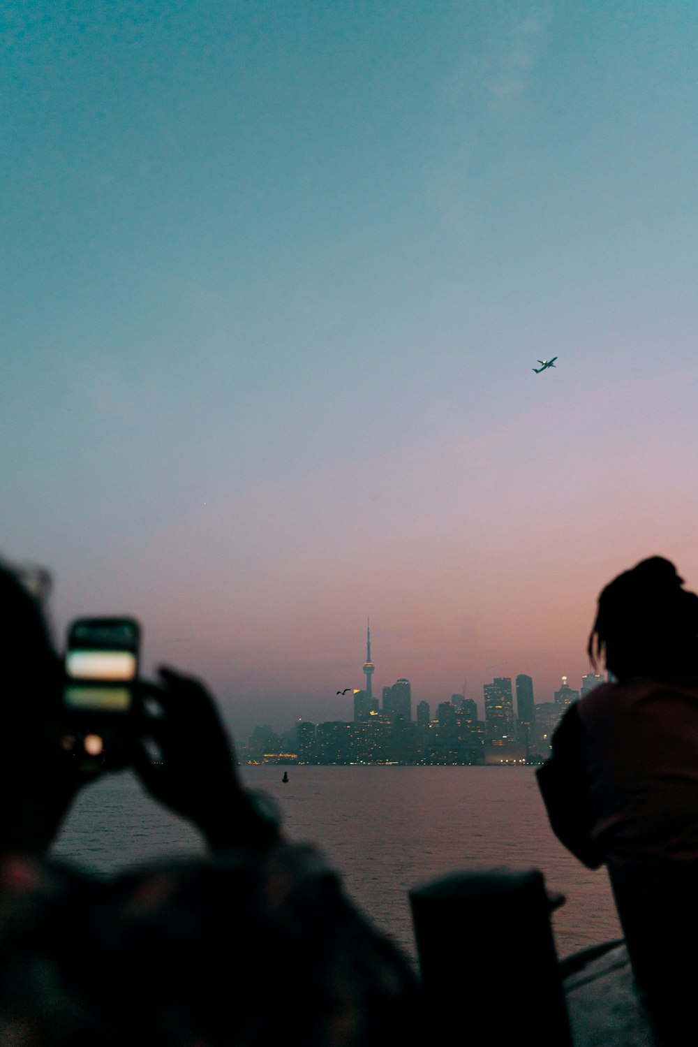 a person taking a picture of a plane in the sky