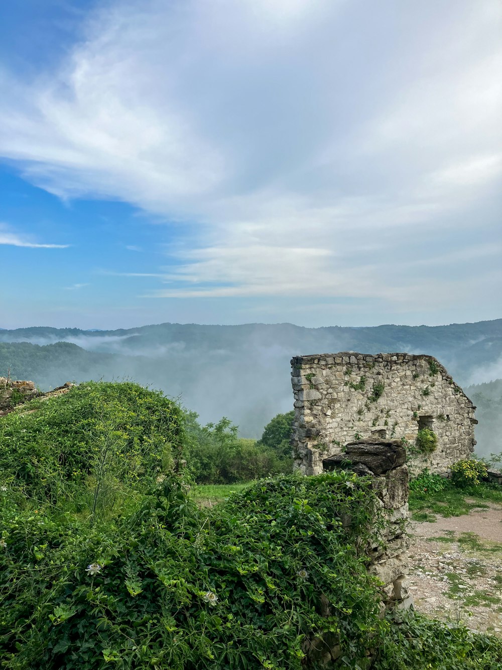 Un bâtiment en pierre assis au sommet d’une colline verdoyante