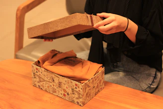 A happy customer unboxing a personalized t-shirt at home.