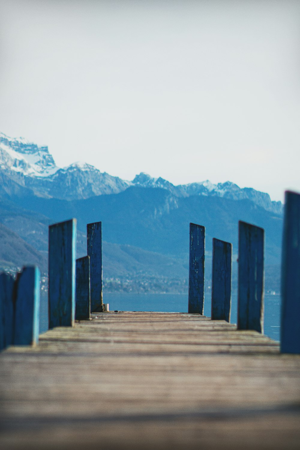 a wooden dock with mountains in the background