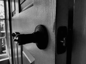 Close-up of a sliding door stuck halfway open with visible damaged rollers and worn track.