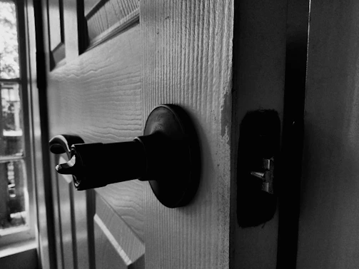 Close-up of a sliding door stuck halfway open with visible damaged rollers and worn track.