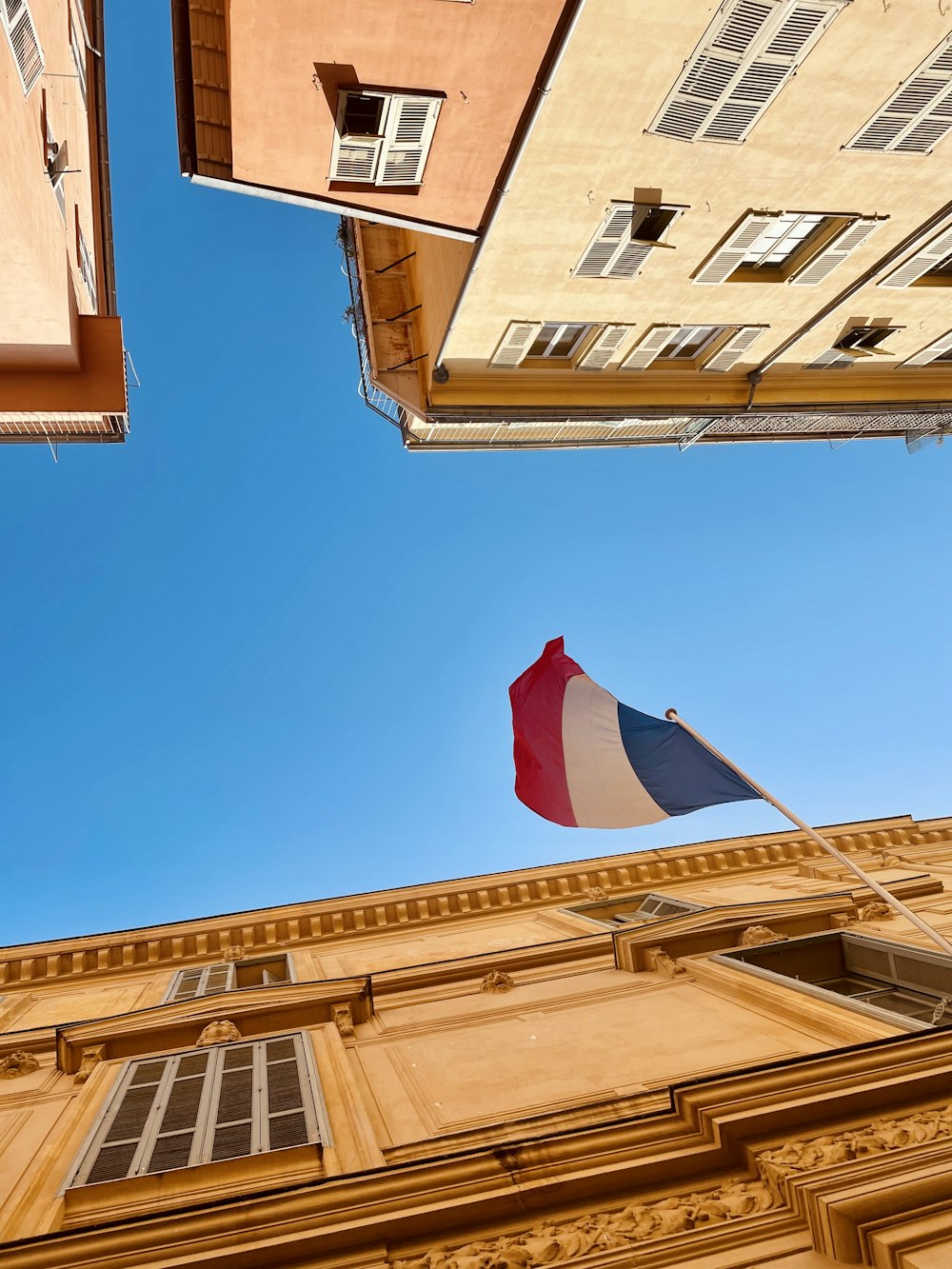 a flag flying in front of a tall building