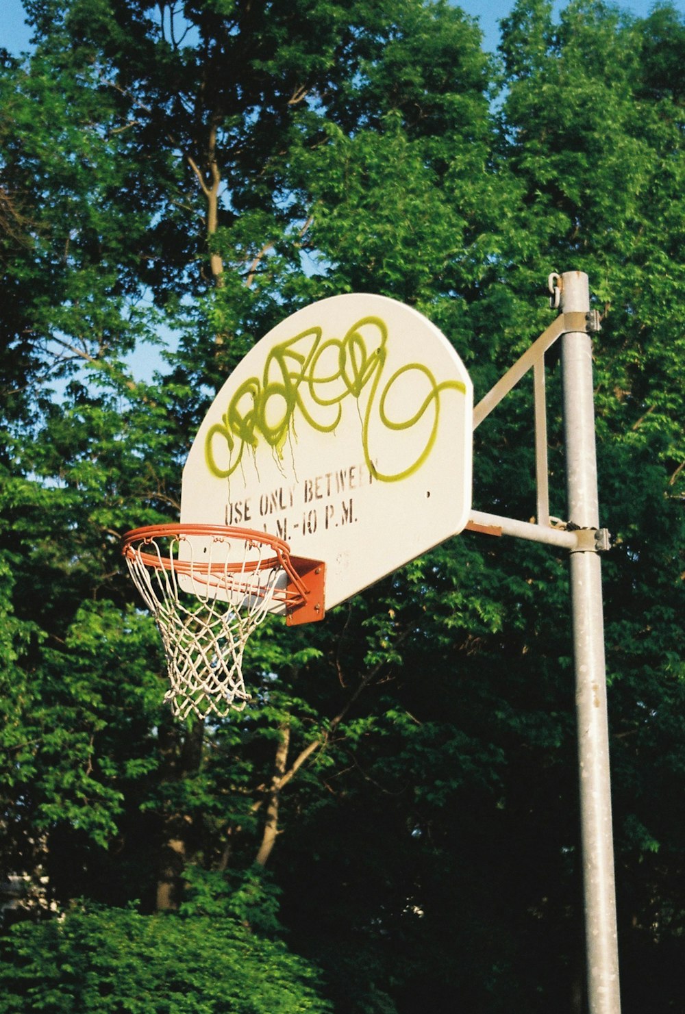 a basketball hoop with graffiti written on it