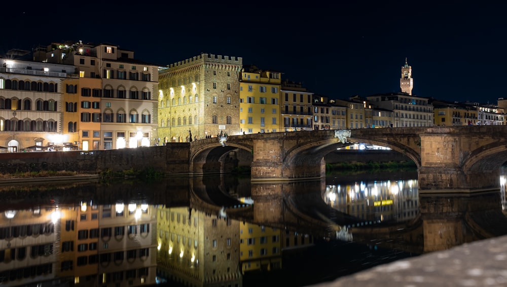 a bridge over a body of water with buildings in the background