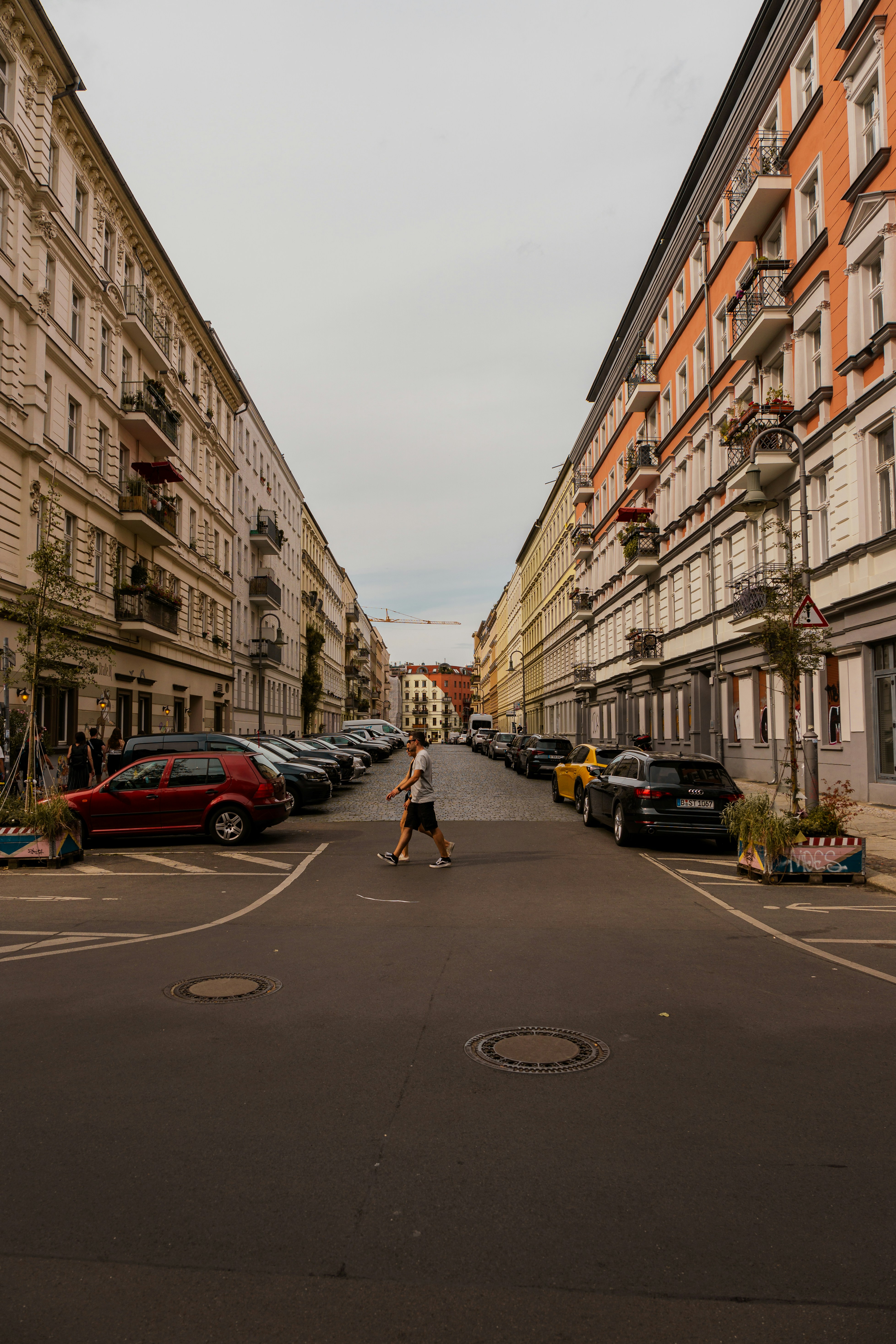 a person walking down a street next to tall buildings