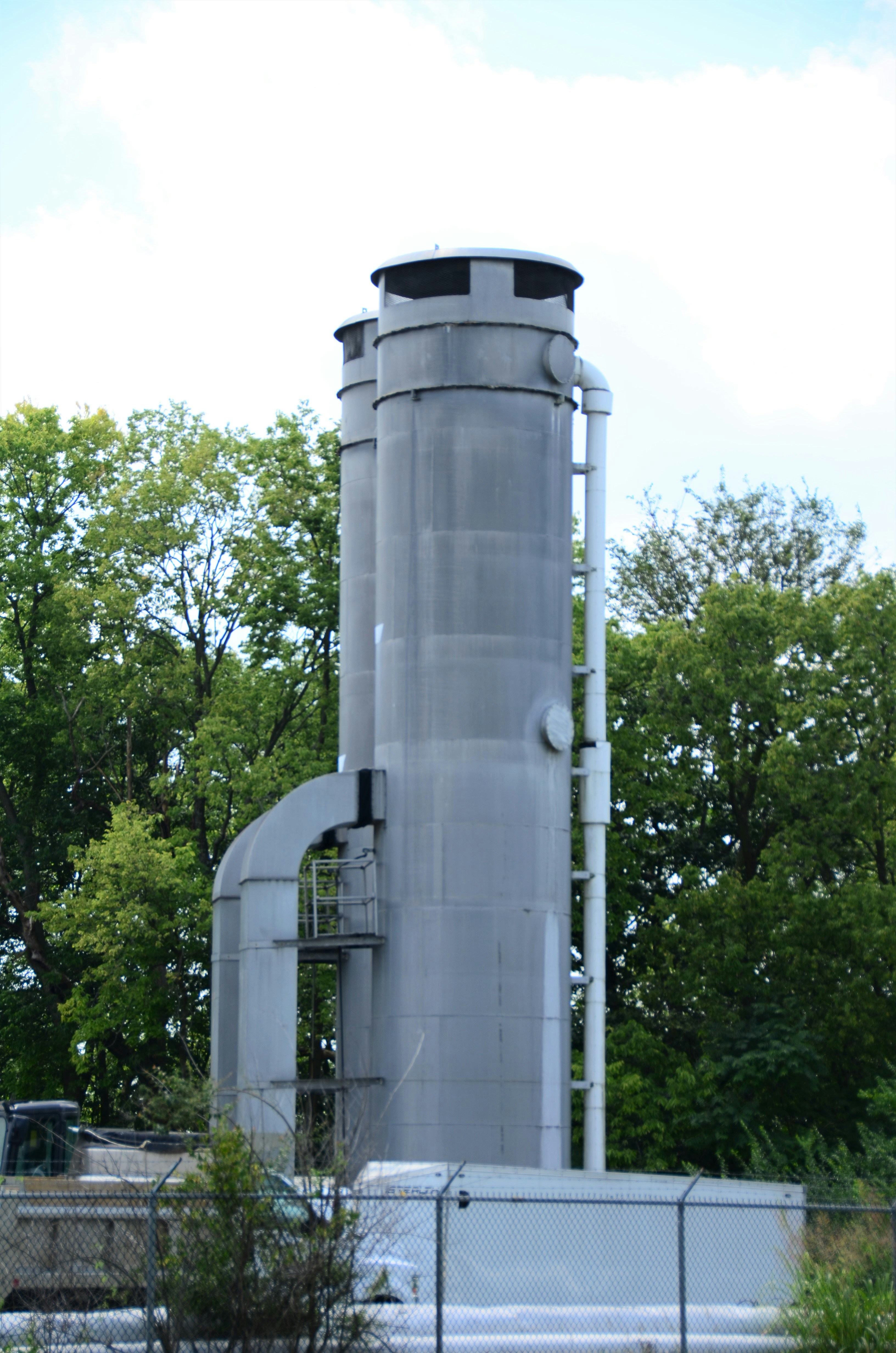 a large metal structure sitting next to a forest