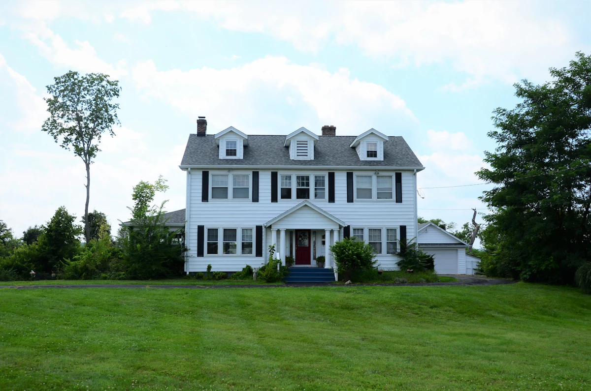 A white colonial house on a wide lawn