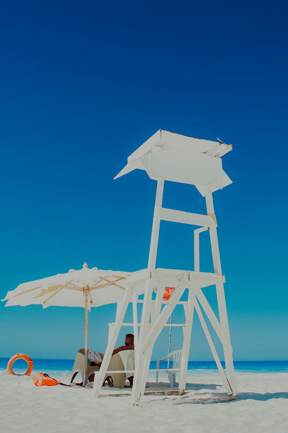 a lifeguard stand on the beach with a life preserver