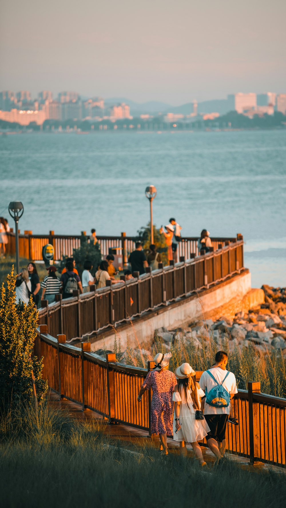 a group of people walking across a bridge next to a body of water