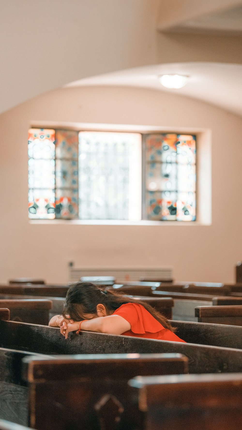 a young girl sitting in a pew in a church