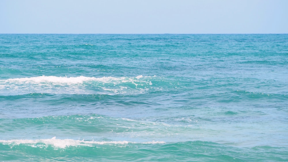 a man riding a surfboard on top of a wave in the ocean