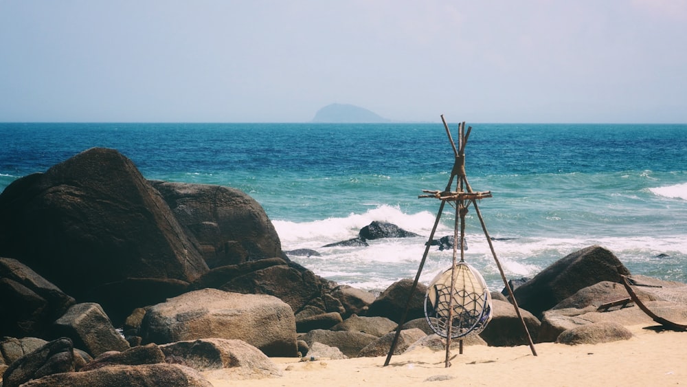 a sculpture sitting on top of a sandy beach next to the ocean