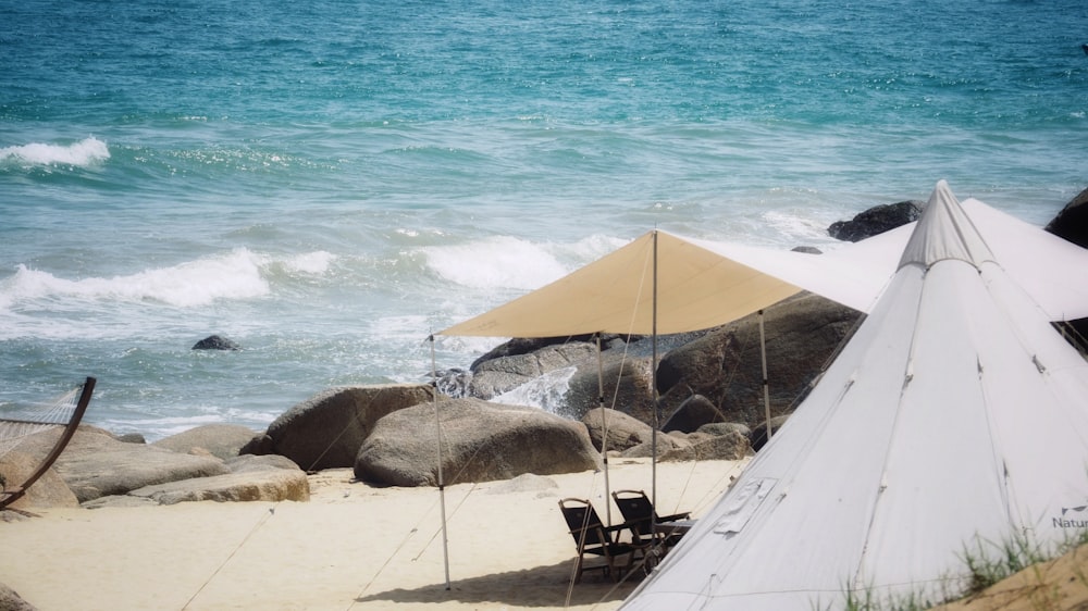 an umbrella and chairs on a beach near the ocean