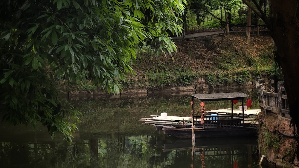 a boat floating on top of a river next to a lush green hillside