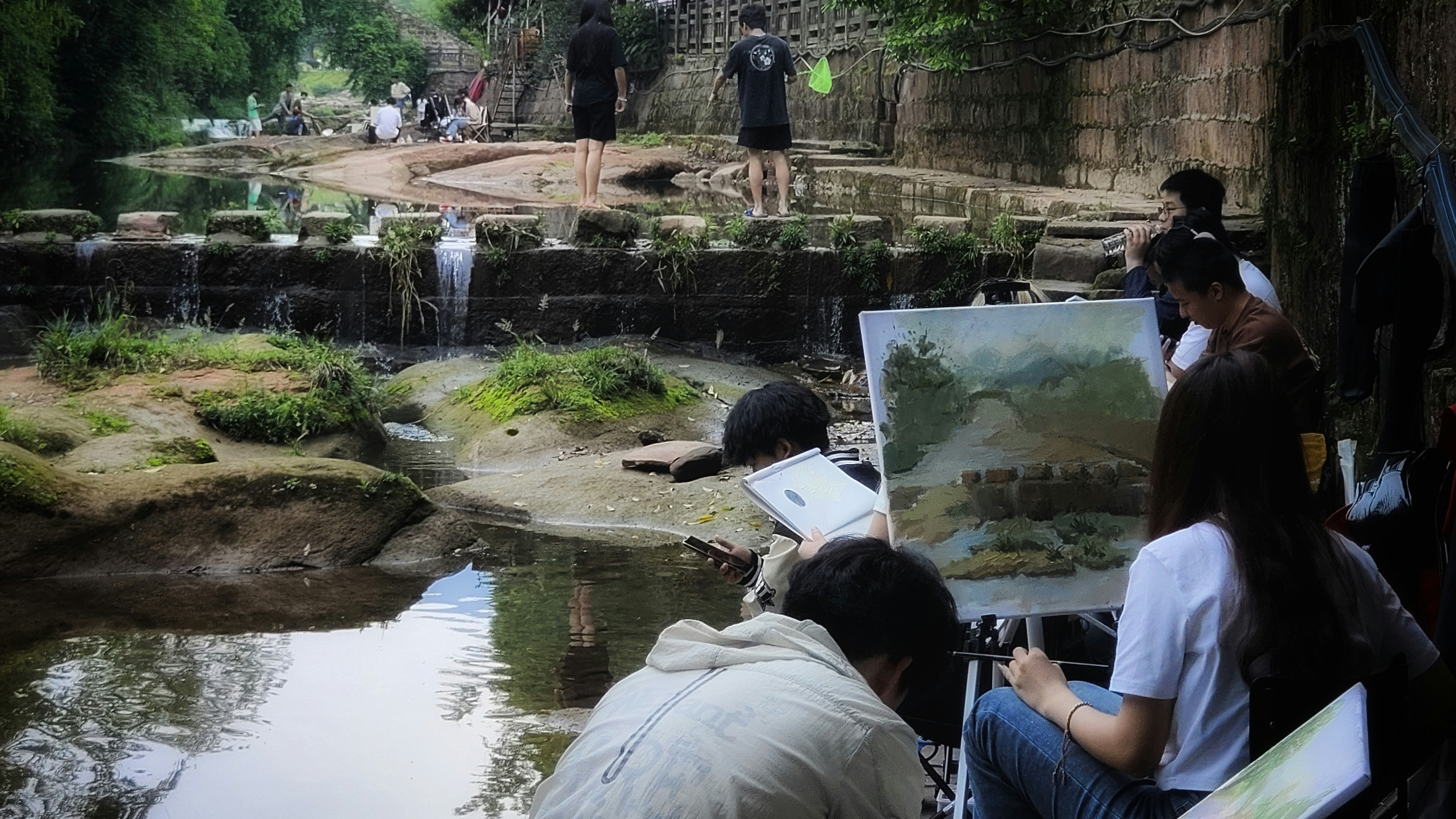 A group of people sitting next to a river photo – Free Book Image on ...