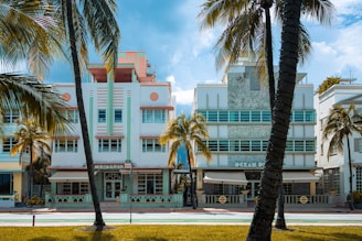 a large white building surrounded by palm trees