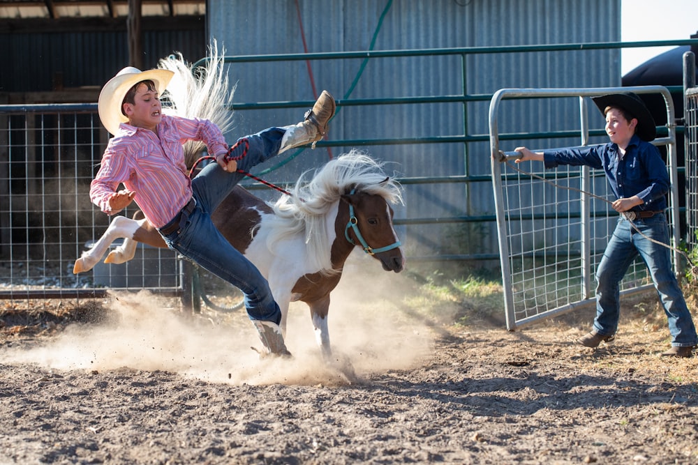 a man riding on the back of a brown and white horse