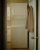 A compact washing machine in a cozy laundry corner.