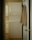 A narrow laundry space features a stacked white washer and dryer positioned against the wall. A beige shirt is hung on the back of the open door leading to the room. The walls and cabinetry are a soft, neutral color, complementing the appliances.