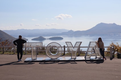 a couple of people standing next to a sign