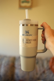 a person holding a coffee cup in their hand
