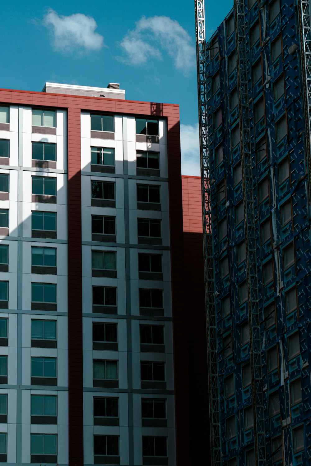 키가 큰 파란색 건물 옆에 있는 높은 빨간색과 흰색 건물
