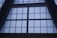 Large, grid-like window structure with several rectangular panes set in a dark metal or concrete frame. The window appears to be part of a tall building, possibly an atrium or a commercial space.