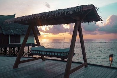 A private deck of a sunset suite overlooking the glowing horizon and calm sea.
