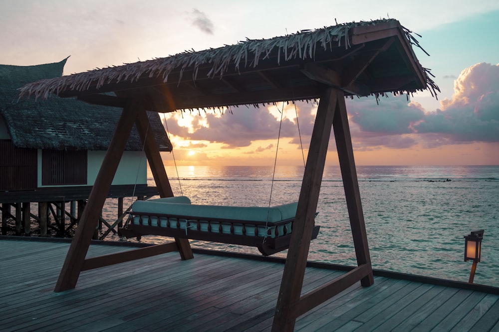 a swing bed sitting on top of a wooden pier