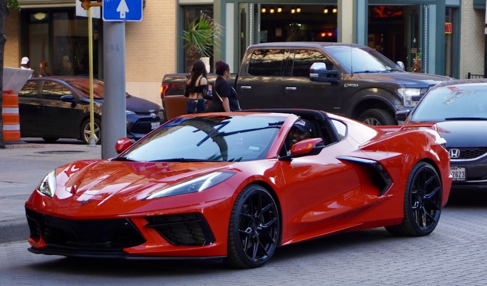 Un coche deportivo rojo estacionado al costado de la carretera