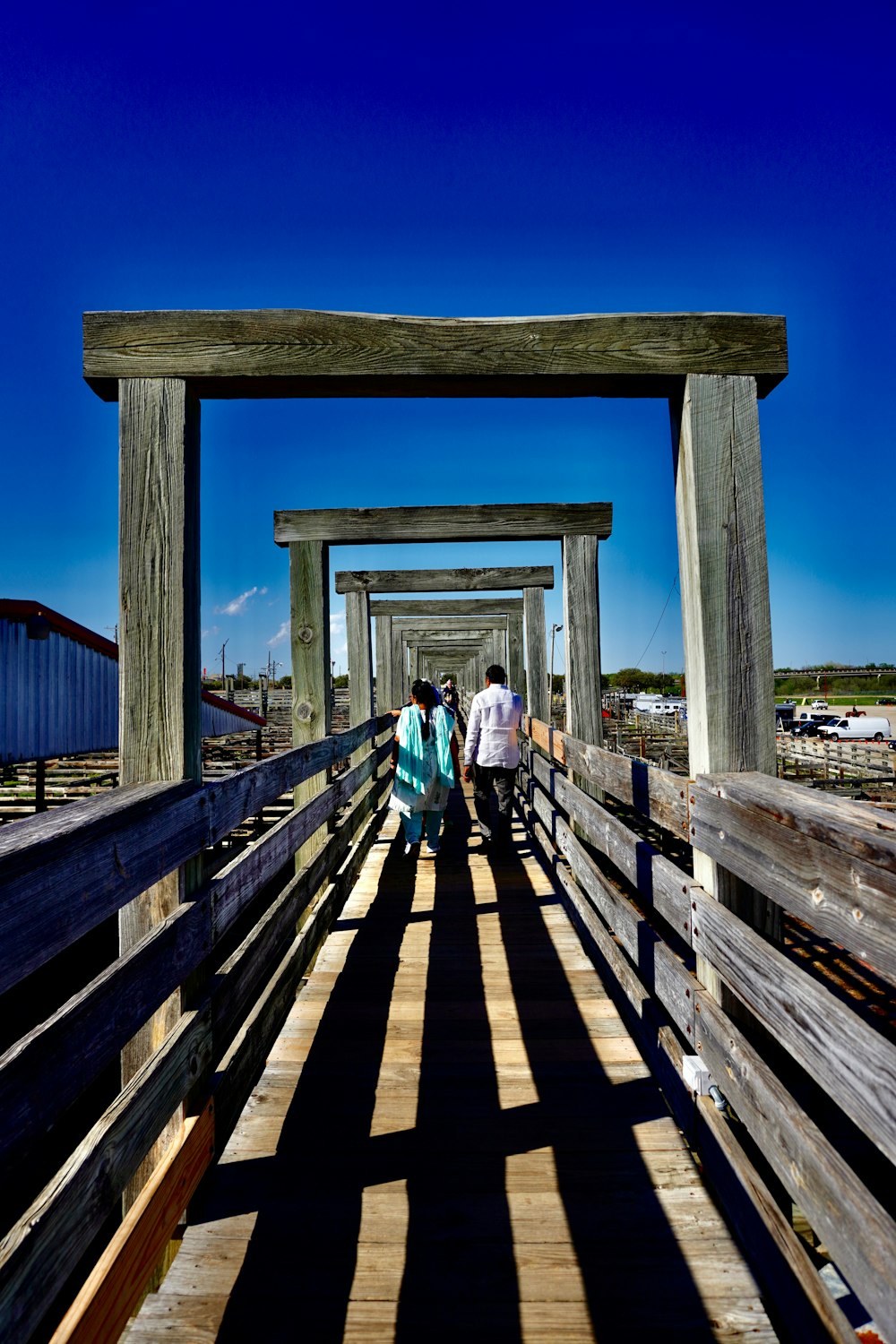 a group of people walking across a wooden bridge