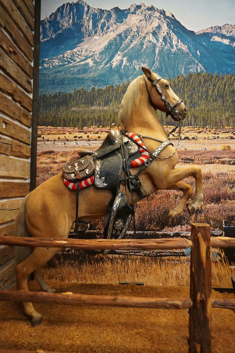 a statue of a horse jumping over a wooden fence