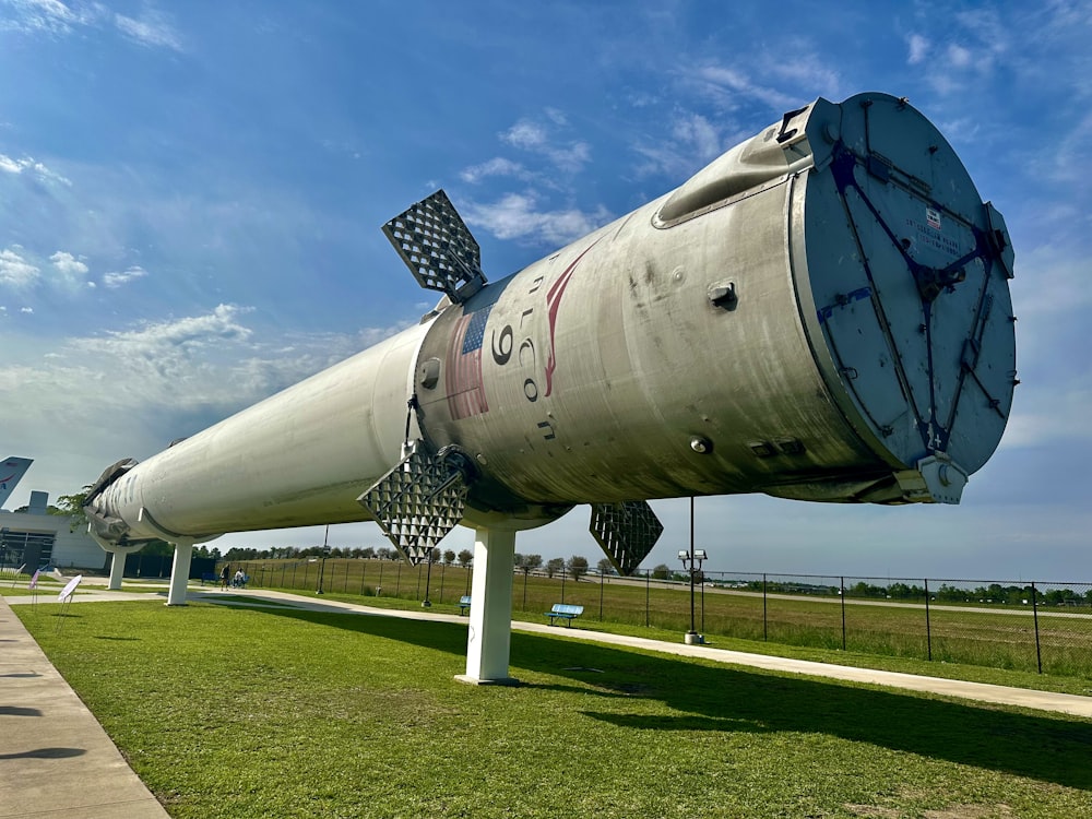 a large rocket sitting on top of a lush green field