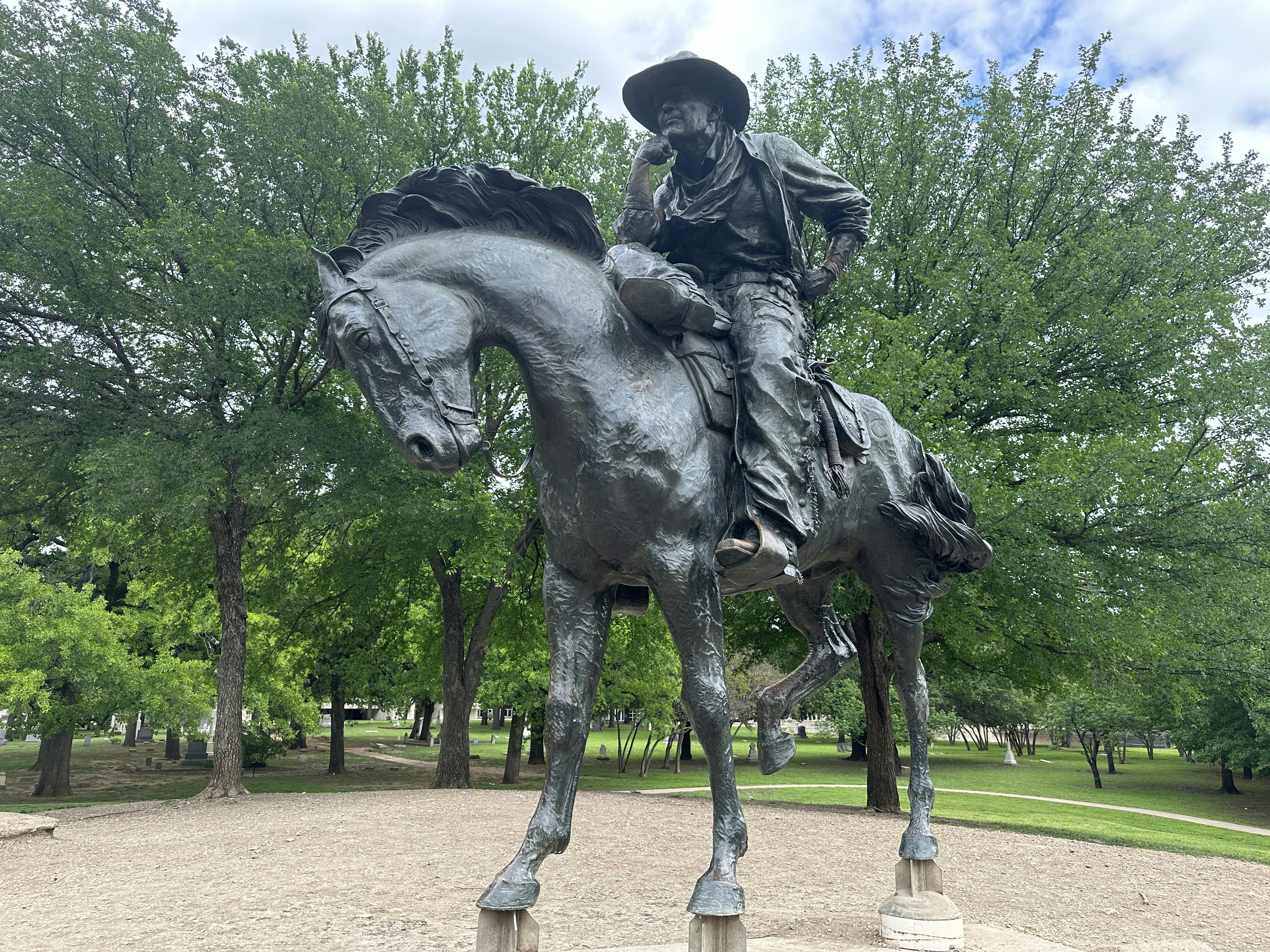 A statue of a man riding a horse in a park photo – Free Pioneer plaza ...