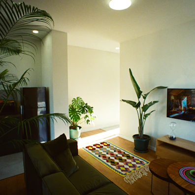 A minimalist, modern living room with neutral colors and pops of earthy green from indoor plants.