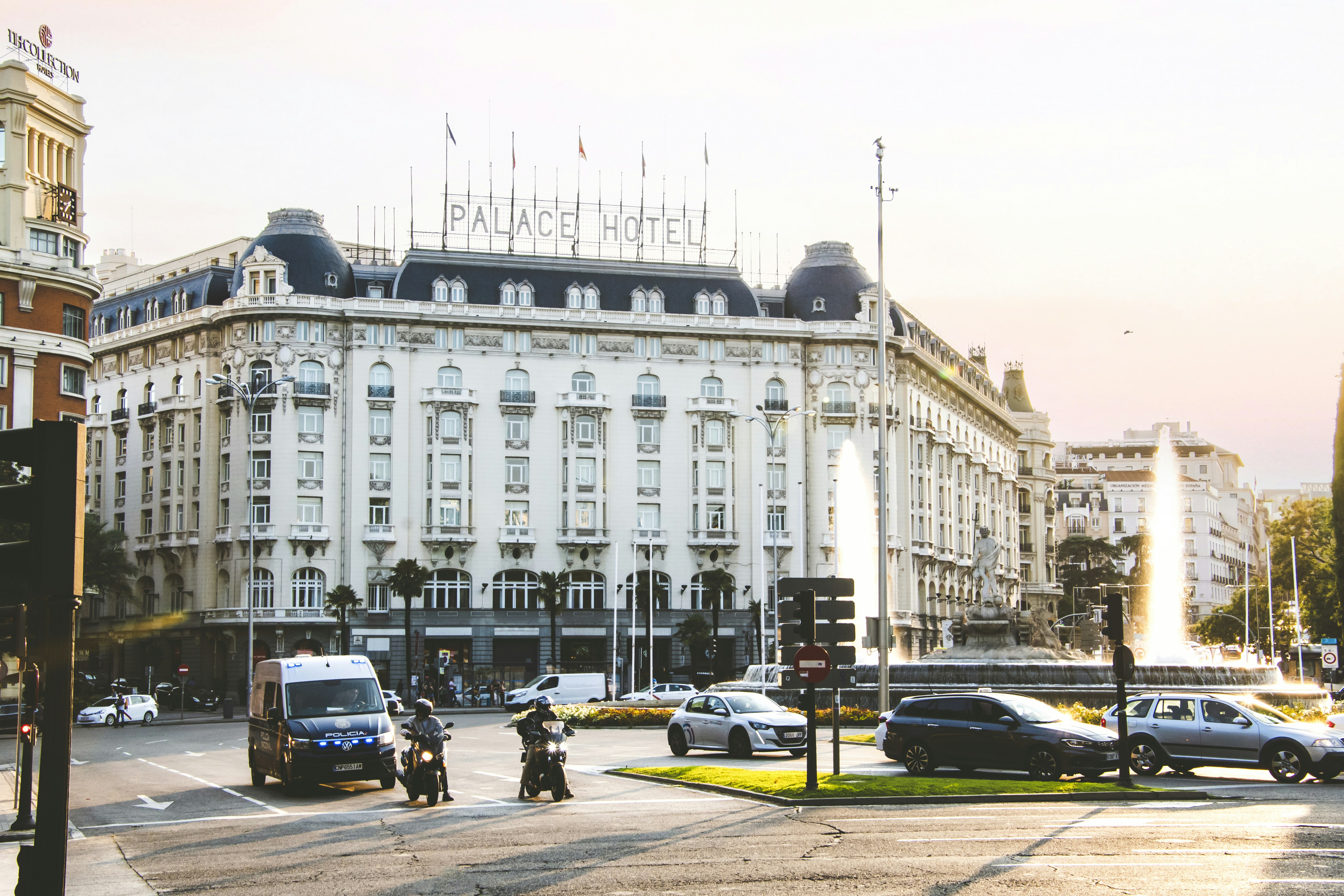 a large white building with a lot of cars on the street, 