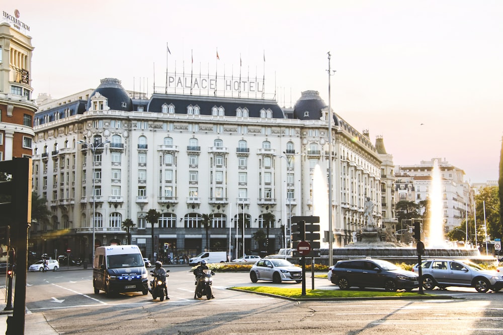 a large white building with a lot of cars on the street