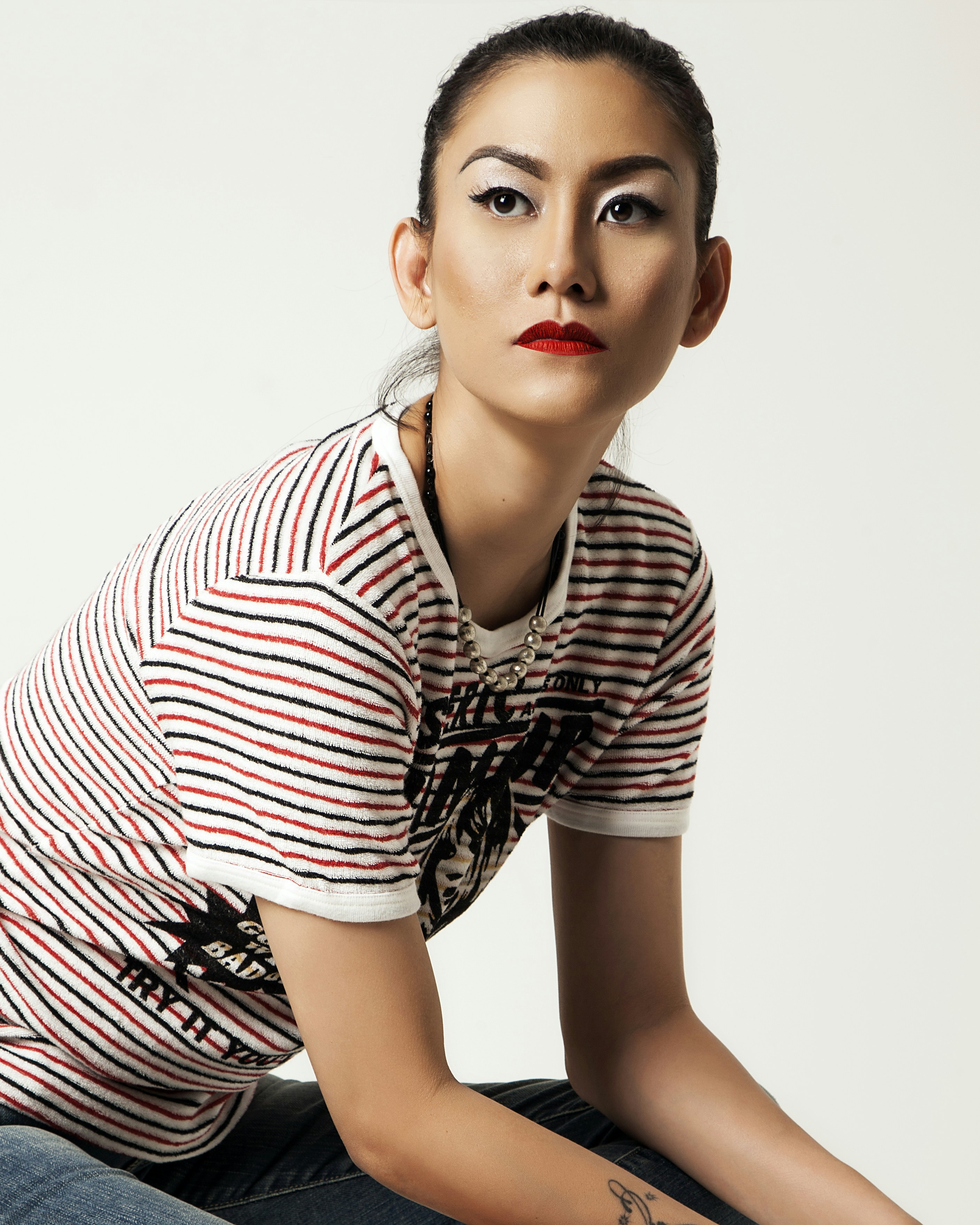 a woman sitting on the ground with a tattoo on her arm