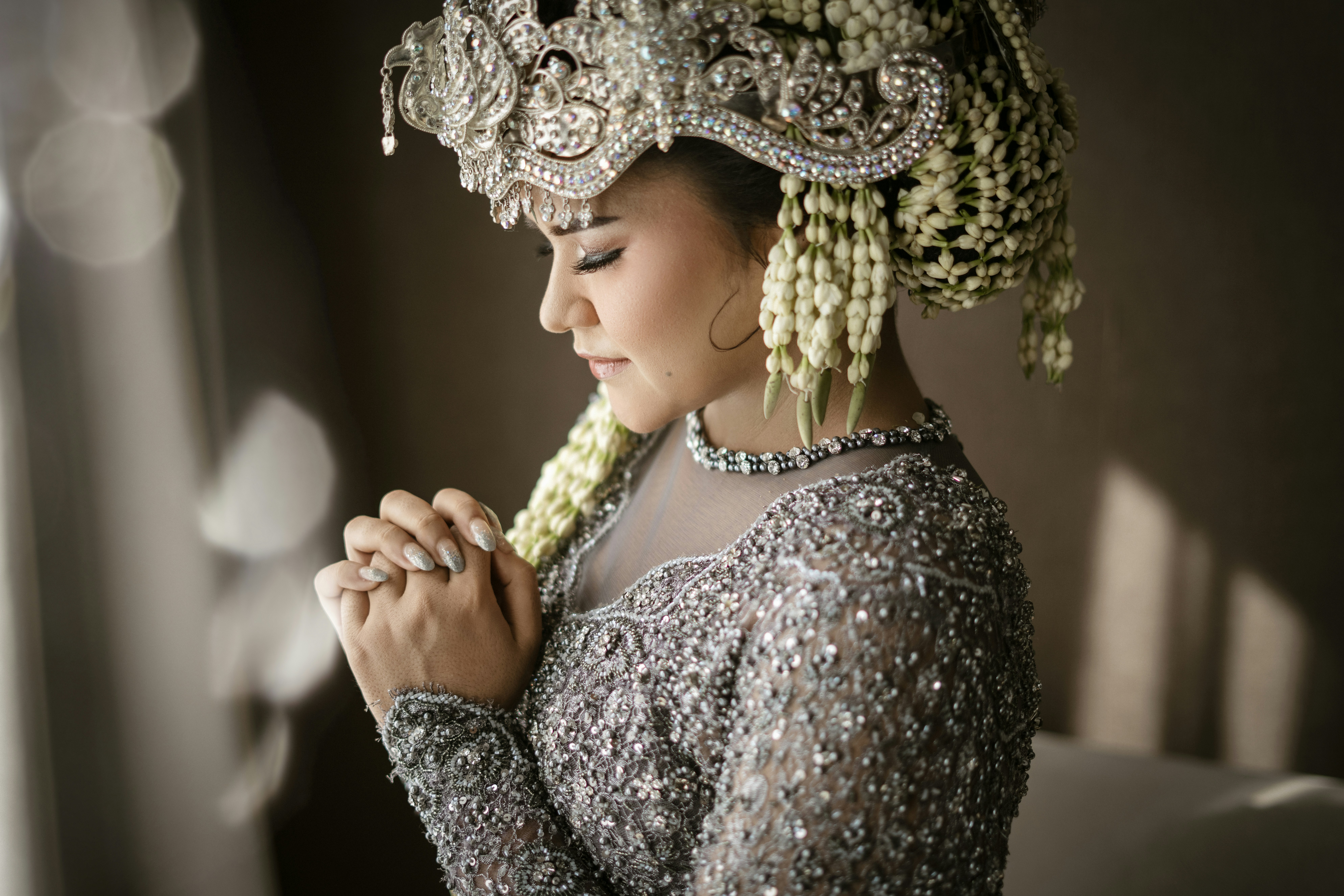a woman in a silver dress with a flower in her hair