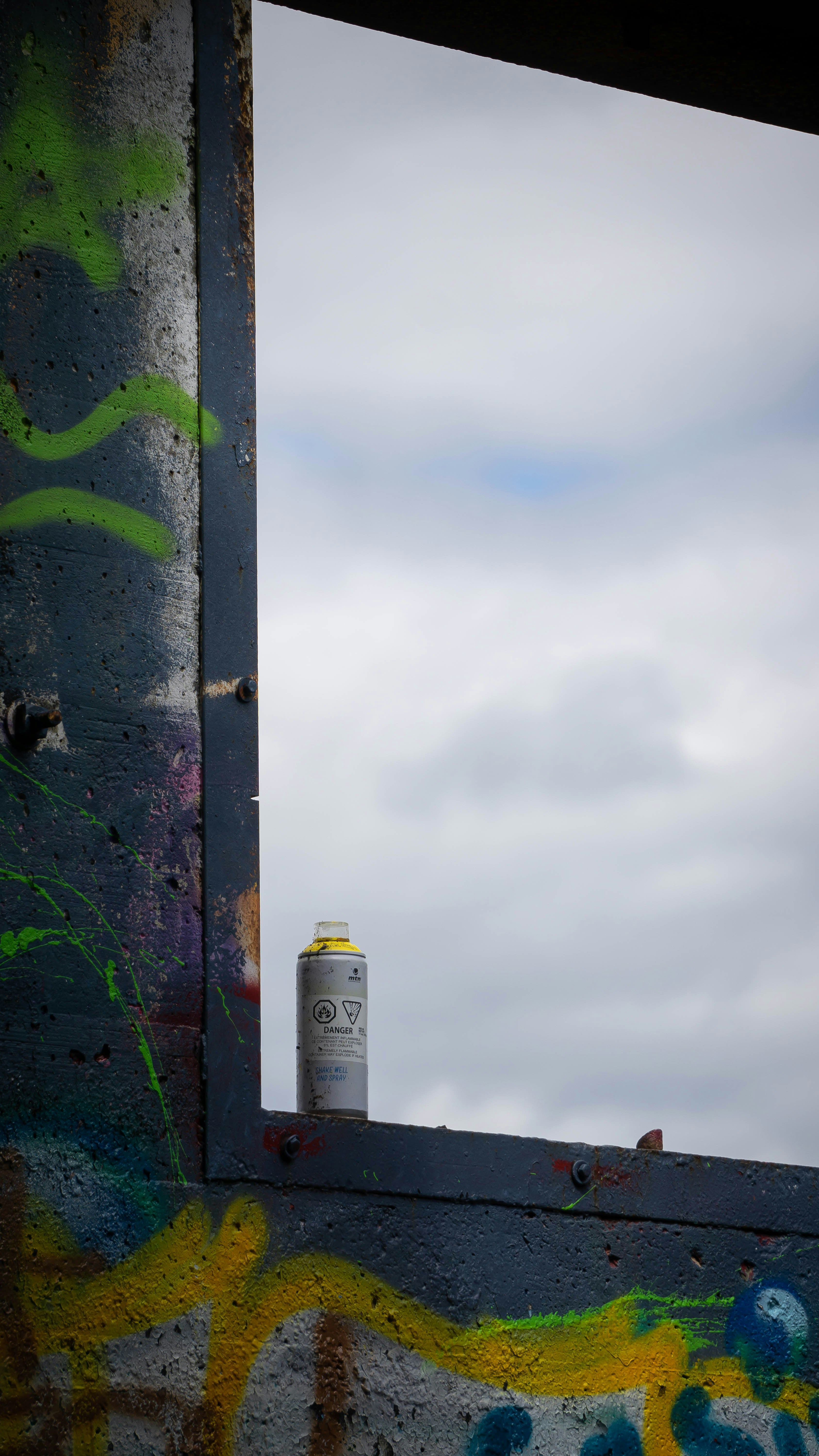a can of spray paint sitting on top of a window sill