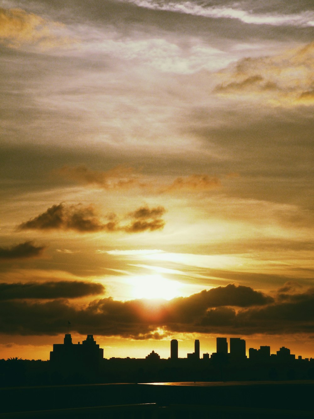 the sun is setting over a city skyline