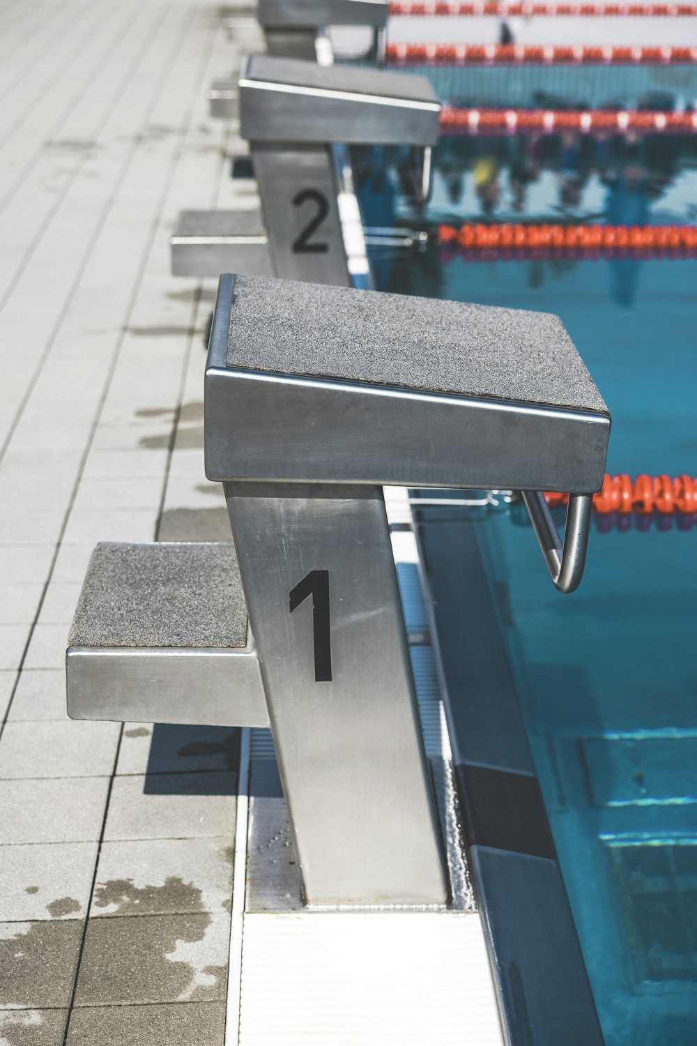 a row of benches sitting next to a swimming pool