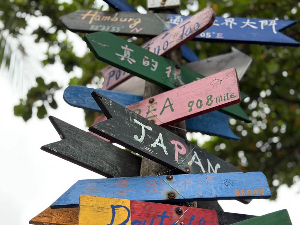 a sign post with many different colored signs on it