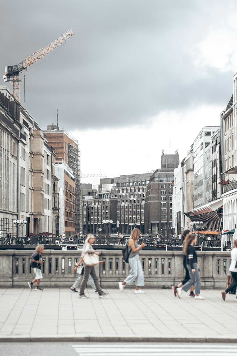 a group of people walking across a bridge