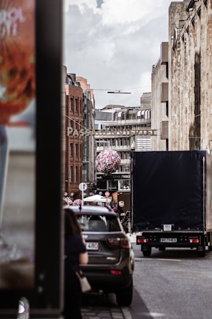 Exterior shot of a cityfahrschule breuer car on a bright city street with modern architecture behind.