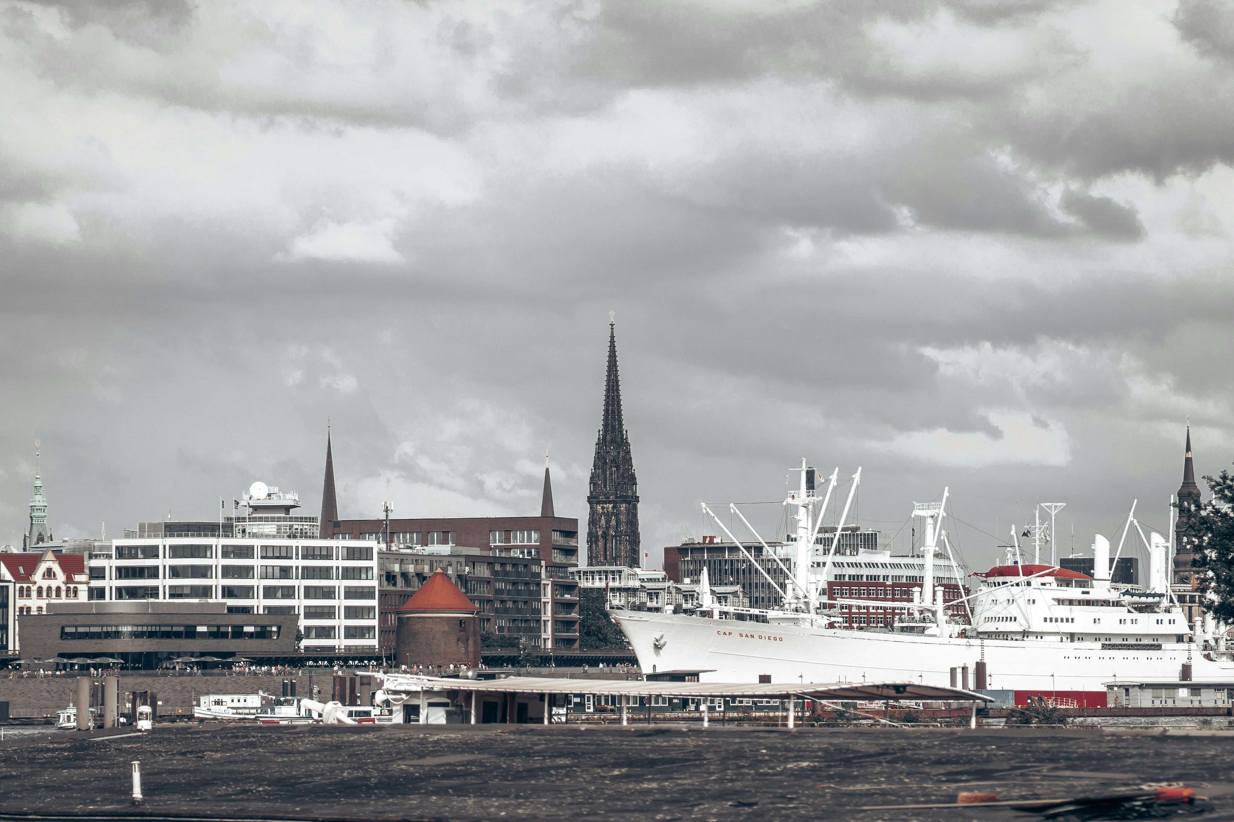 a large white boat in a harbor next to a city