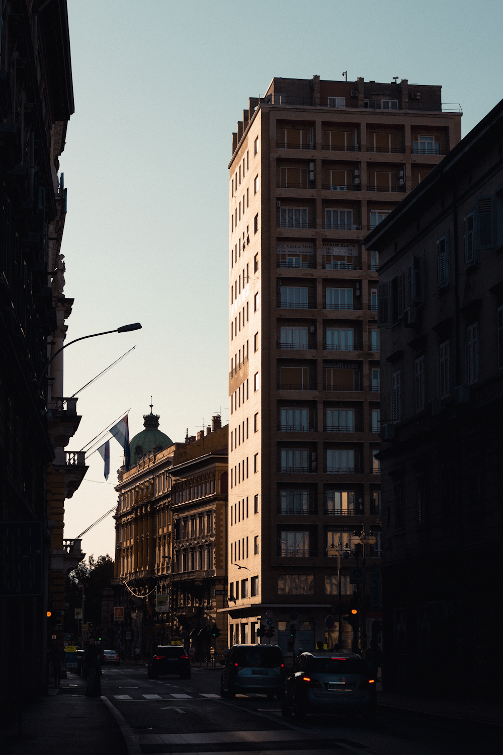 a city street filled with traffic next to tall buildings