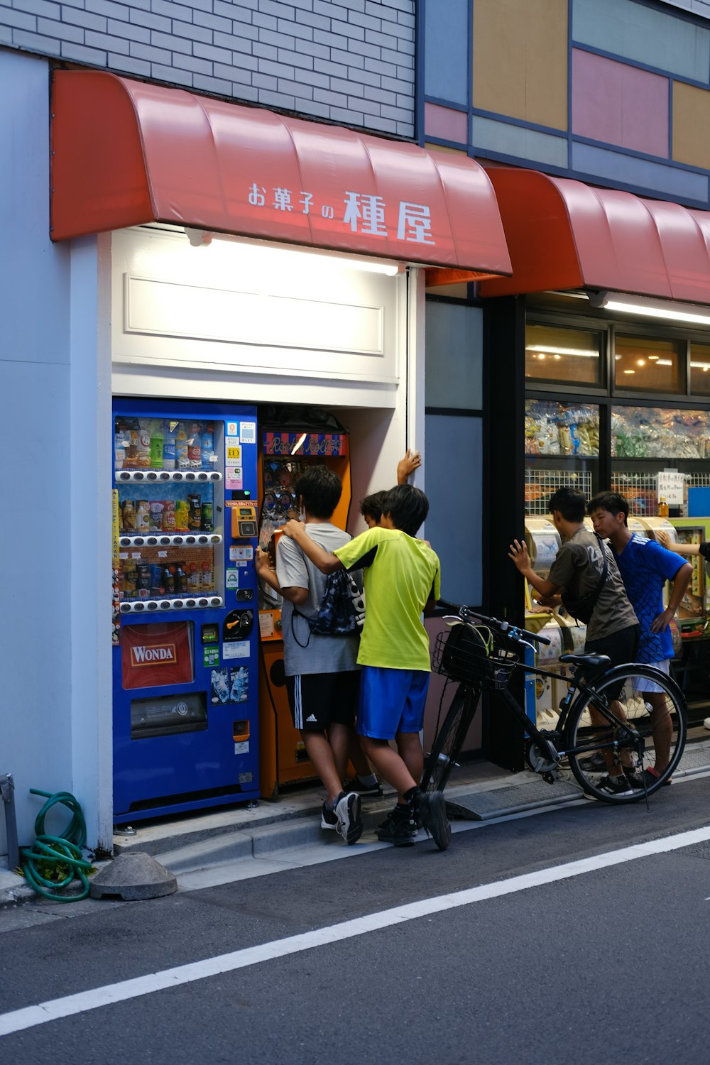 a group of people standing in front of a vending machine